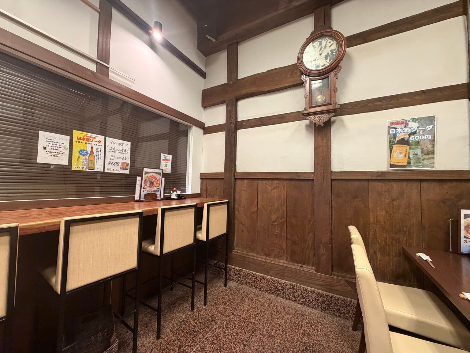 木のカウンターと席が並ぶ、落ち着いた店内