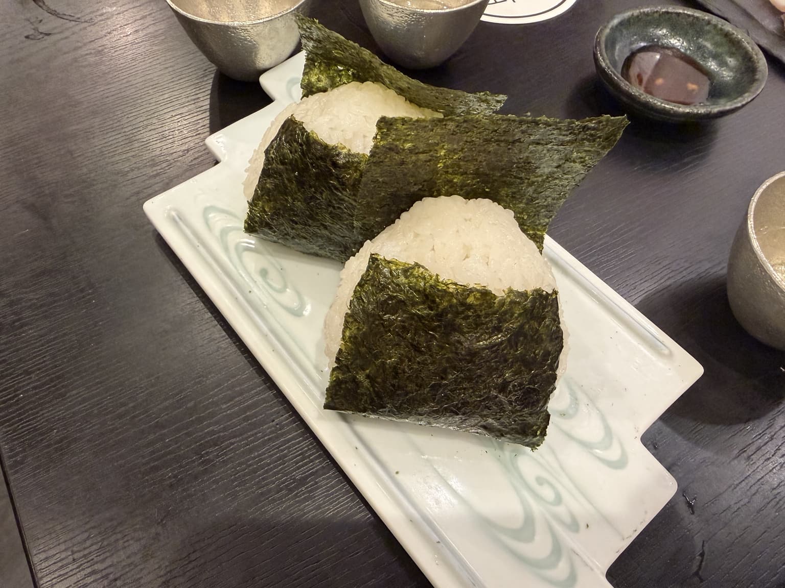 おにぎりと小鉢が並ぶ、食事の途中の和の食卓
