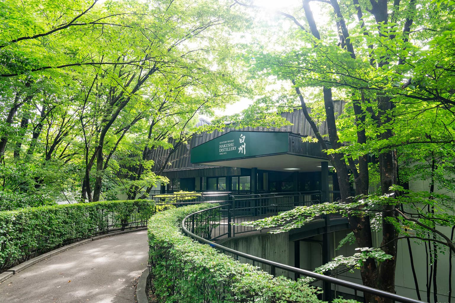緑の木々に囲まれたサントリー白州蒸溜所の入口