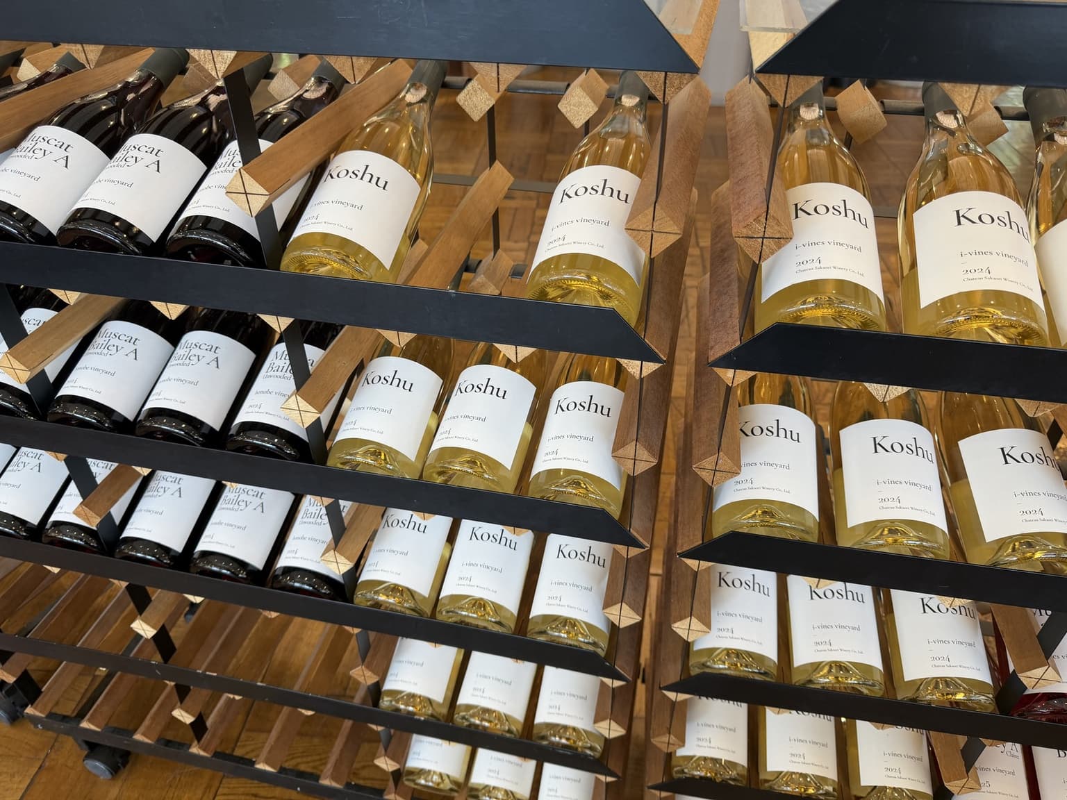 シャトー酒折の棚に並ぶ、KoshuとMuscat Bailey Aの品種名が読めるワインボトル